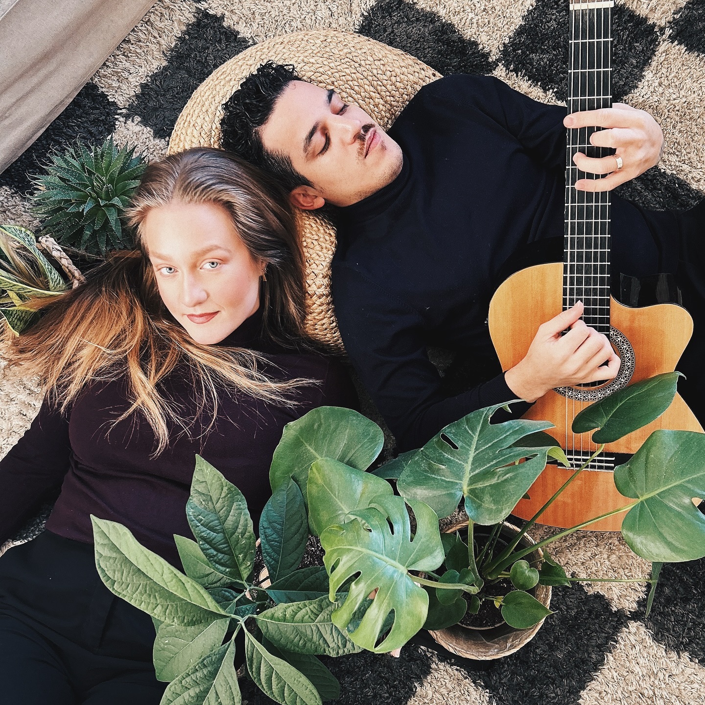 Vilma Olsson and Danel Estrada with a guitar, surrounded by greenery.
